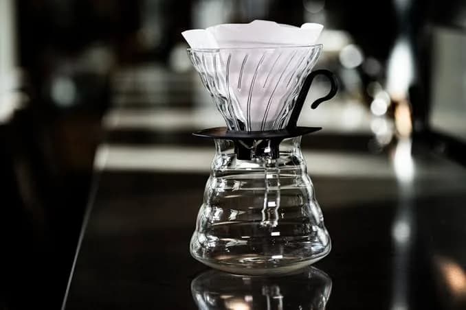 Karanlık bar tezgâhında filtre kâğıtlı cam V60 ve servis sürahisi